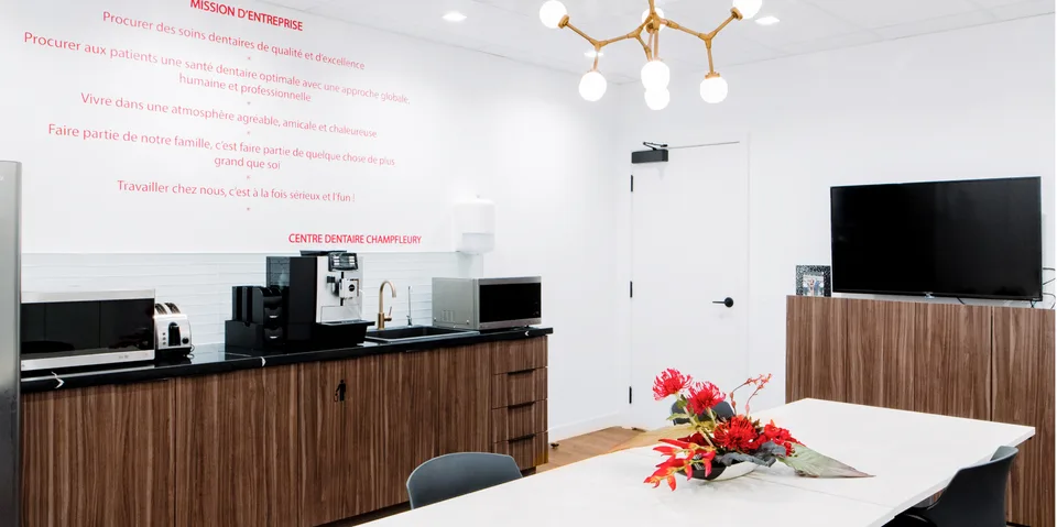 Coin repas avec table, kitchenette, machine à café et téléviseur.