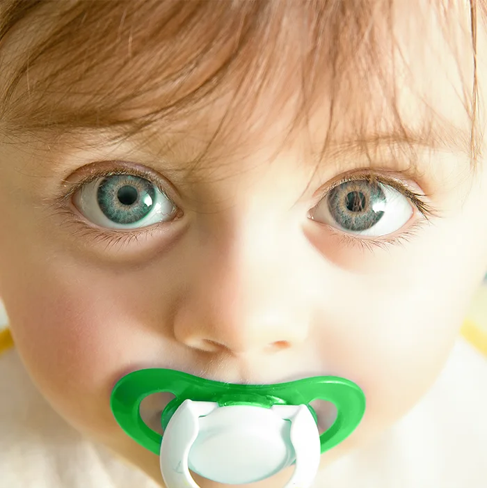 Child with a green pacifier, from the clinic’s original educational page